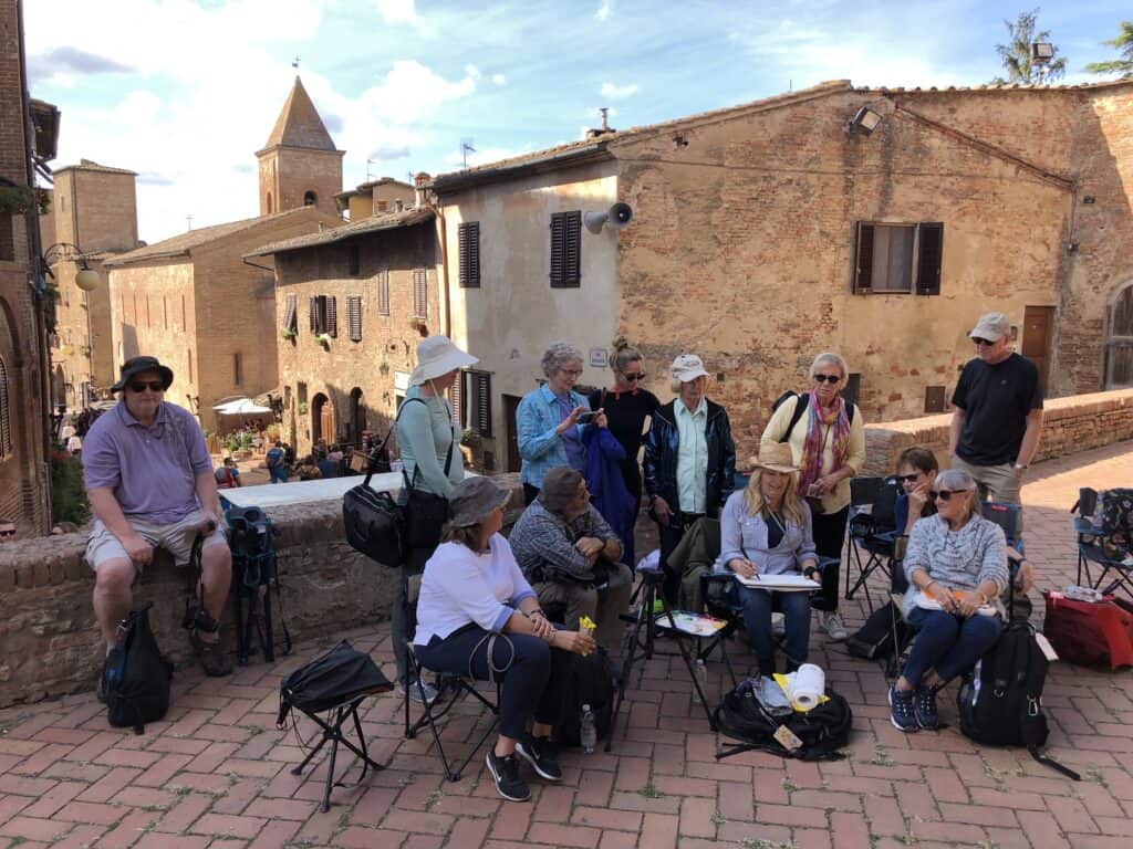Group of artists painting outdoors together, highlighting the benefits of safety and support while engaging in the activity of painting outdoors with a group